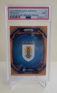 2024 PRIZM COPA AMERICA URUGUAY TEAM BADGE ORANGE PRIZM #9 Ser #11/25 PSA 9 - Picture 1 of 2