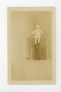 Moody shot of figure holding baby over railing - vintage snapshot found photo - Picture 1 of 3