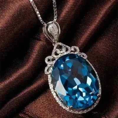 Colgante con halo de topacio azul de corte ovalado de 2 quilates enchapado en oro blanco de 14 quilates plateado Foto 1 de 4