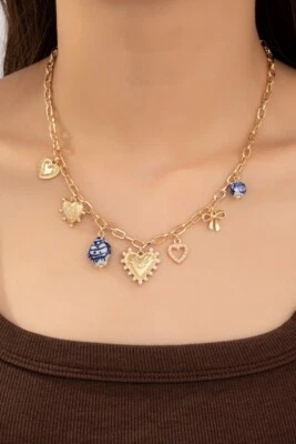 Collar con dije de eslabones de oro | Cuentas de porcelana azul y blanco | Dijes de corazón y lazo Foto 1 de 4