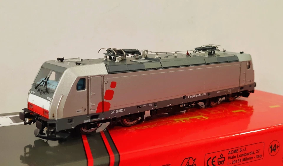 ACME 60632 Locomotiva TRAXX 483 309 livrea ''AKIEM'' argento con pallini rossi , - Immagine 1 di 1