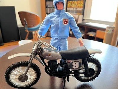 Big Jim Mattel pilota auto da corsa blu chiaro vestito Honda moto Wolfpack CONFEZIONE - Immagine 1 di 4