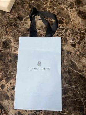 Bolsa de regalo de papel azul vacía The Ritz Carlton y un bloc de notas de color azul Foto 1 de 4