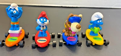 Lote de 4 Hardees Smurfs en monopatines Peyo Applause 1990 Foto 1 de 4