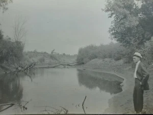 Antiguo RPPC de la década de 1900 Suited Man Surveys Muddy Pond Lagoon años 1910 - Imagen 1 de 3