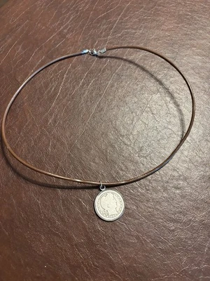 Cuarto de barbero de plata 1902 en un estrecho cordón de cuero encerado marrón.  Histórico. Foto 1 de 3