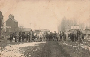 TWENTY HORSES WITH OWNERS ON SNOWY DIRT STREET BY RR CARS VINTAGE RPPC 091723 S - Picture 1 of 5