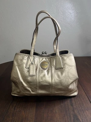 Bolso de mano Coach de cuero dorado metálico con logotipo en relieve Foto 1 de 4