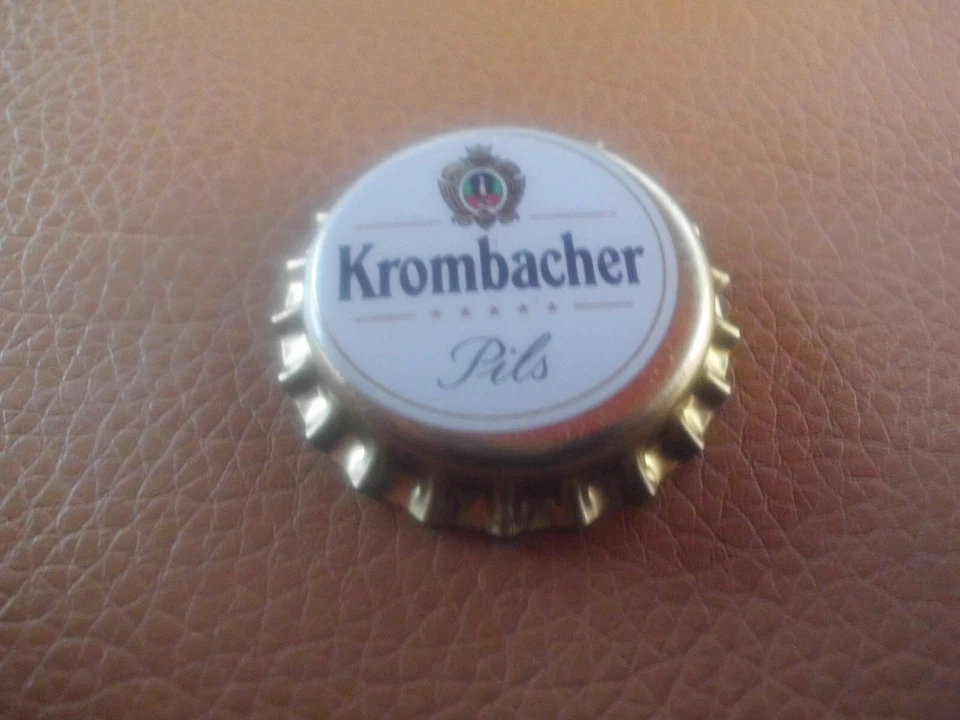 Unbenutzter, gold-weisser Kronkorken Krombacher Pils (mit Linien und Sternen) - Bild 1 von 1