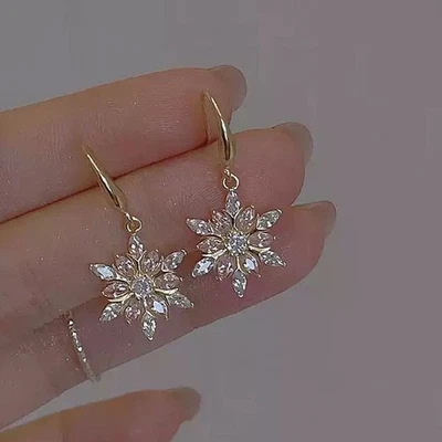 Pendientes colgantes de cristal de copo de nieve dorado para mujer - aros colgantes de invierno de circonita cúbica brillante Foto 1 de 4