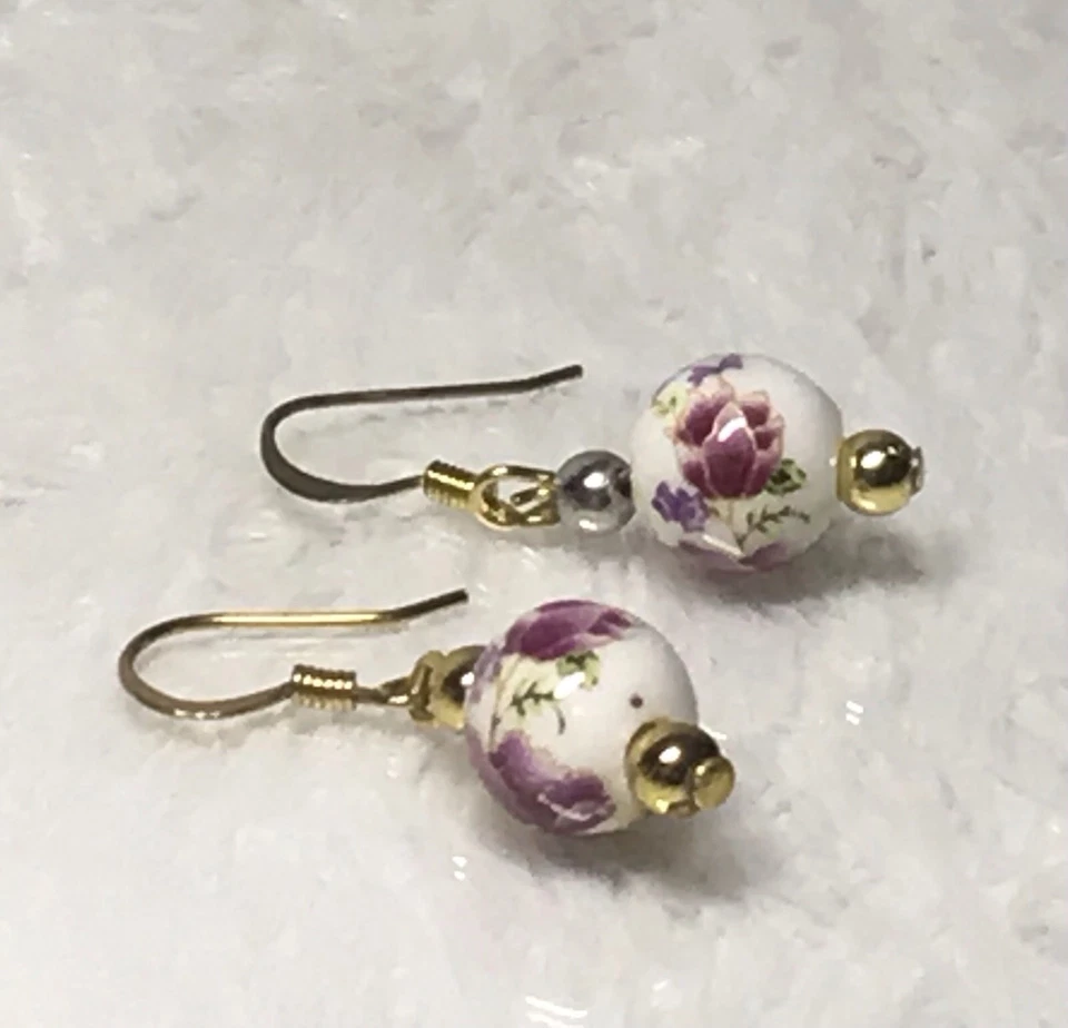 Pendientes delicados de cerámica con diseño floral en ganchos de oro Foto 1 de 1