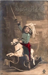 LITTLE BOY WITH SWORD RAISED : RIDING A SPIRITED ROCKING HORSE : RPPC : (1906) - Picture 1 of 3