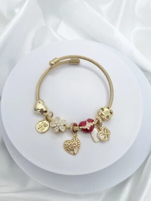 Brazalete de cable trenzado Linx de oro amarillo con dijes temáticos rojos y dorados Foto 1 de 4