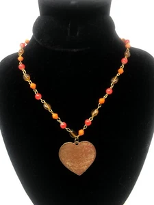 Collana vintage di perline arancioni e ambra con ciondolo cuore in ottone inciso - Foto 1 di 9