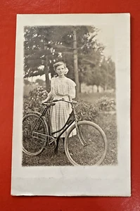 ANTIGUA POSTAL RPPC 1909 ~ JOVEN ELDORA IOWA MUJER EN VESTIDO POSANDO CON BICICLETA - Imagen 1 de 2