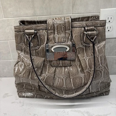 Bolso de mano Guess imitación piel de anguila tostado con pedrería plateado logotipo asas Foto 1 de 4