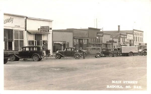 Kadoka SD Main Street Groceries Meats Store Old Cars Truck RPPC - Picture 1 of 2