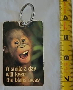 Vintage Schlüsselanhänger "A SMILE A DAY WILL KEEP THE BLAHS AWAY" Neuheit BABY ORANG-UTAN - Bild 1 von 3