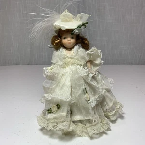 Porzellanpuppe mit Spitzenkleid und Creme/Motorhaube, braune Haare 8" groß - Bild 1 von 3