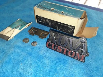 Nuevo de Lote Antiguo GM 1975 NOVA PARRILLA PERSONALIZADA EMBLEMA REJILLA DELANTERA ORNAMENTO 75 PLACA DE IDENTIFICACIÓN CON TUERCAS Foto 1 de 4
