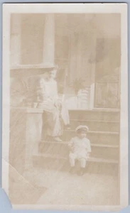Mujer y niño pequeño, porche, columnas, plantas en maceta, foto instantánea sepia años 1900-20 - Imagen 1 de 2