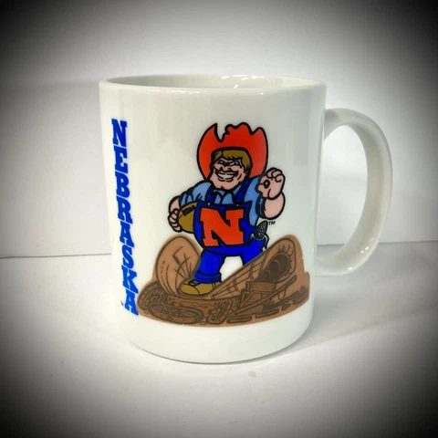 vtg NEBRASKA CORNHUSKERS COFFEE MUG Herbie Husker mascot university seal WHITE Cover