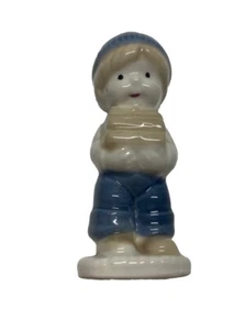 De colección. Estatuilla de porcelana pintada a mano de niño azul que lleva madera - Imagen 1 de 4