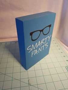 Letrero de madera pintado azul con gafas negras lee "Pantalones inteligentes" - 5 X 1,5 X 7 pulgadas - Imagen 1 de 11
