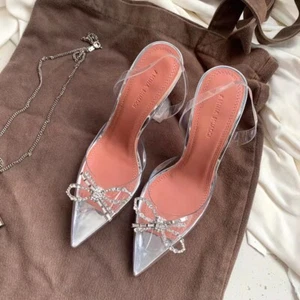 Sandalias Amina Muaddi con hebilla de estrás para mujer con lazo en punta tacón delgado Mullers transparentes - Imagen 1 de 24