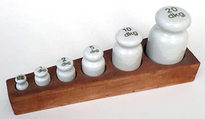 7 alte Porzellan Gewichte im Holzkasten 1/2 dkg bis 20 dkg Österreich orig. 30er - Bild 1 von 2
