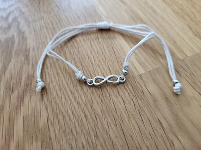 Armband weiß mit silbernem Infinity Anhänger größenverstellbar von Accessorize - Bild 1 von 2