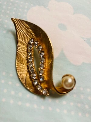 VINTAGE GOLD TEXTURED METAL BROOCH W/ROW OF RHINESTONES AND FAUX PEARL 2''X1'' - Image 1 of 4