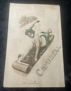 Postal de artista Campbell toboganning mujer en sombrero c1911 - Imagen 1 de 2