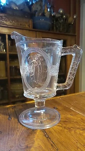 "Antigua jarra de crema de vidrio de patrón americano temprano EAPG, Venus y Cupido, 6" - Imagen 1 de 3