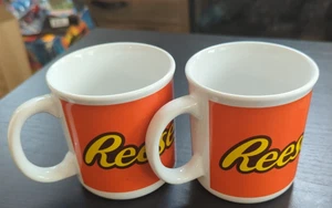 2er Set Galerie Reese's Orange Keramik Kaffeetassen mit gelbem Logo - Bild 1 von 6