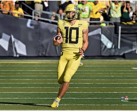 Justin Herbert Oregon Ducks Unsigned Yellow Jersey Running with Ball Photograph Cover