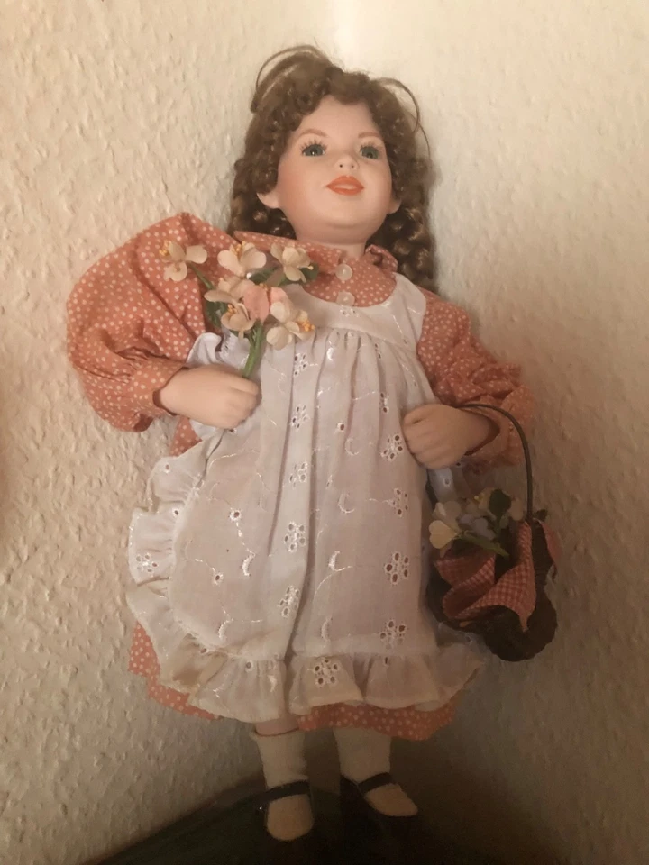 Puppe mit braunen Zöpfen, mit Körbchen, aus Hartplastik oder ähnlichem Material - Bild 1 von 1