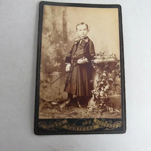 Antiguo gabinete tarjeta fotografía niño con vestido sosteniendo un bastón - Imagen 1 de 2