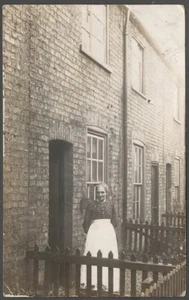 Antigua postal británica con foto postal británica Woman in City Building Alley pequeño patio piquete cerca - Imagen 1 de 2