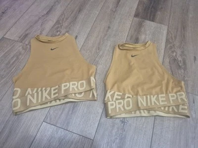 Conjunto de 2 camisetas cortas Nike Pro ajustadas de entrenamiento deportivas cuello alto entrelazadas Xs doradas  Foto 1 de 4