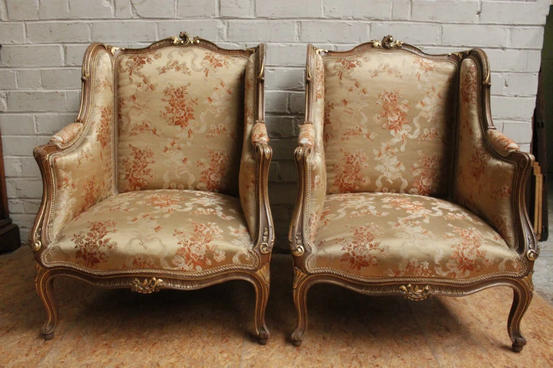 Par de sillones Bergere franceses antiguos Luis XV dorados sobre nogal Foto 1 de 4