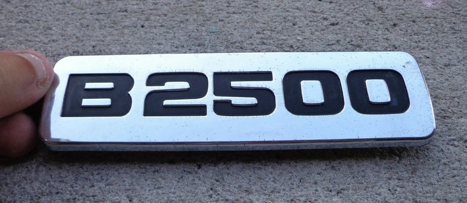 Mazda B2500 emblema para-lama emblema decalque logotipo símbolo OEM genuíno original de fábrica - Imagem 1 de 1