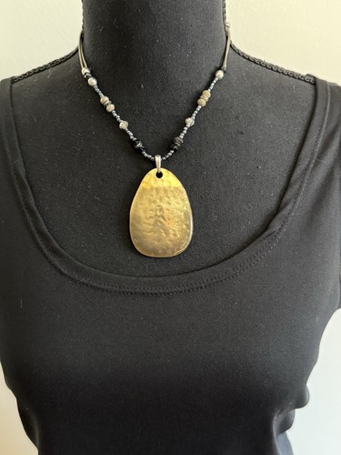 VETEMENTS Collana tribale tono oro e cordino nero 20" perline tono oro ciondolo metallo ovale