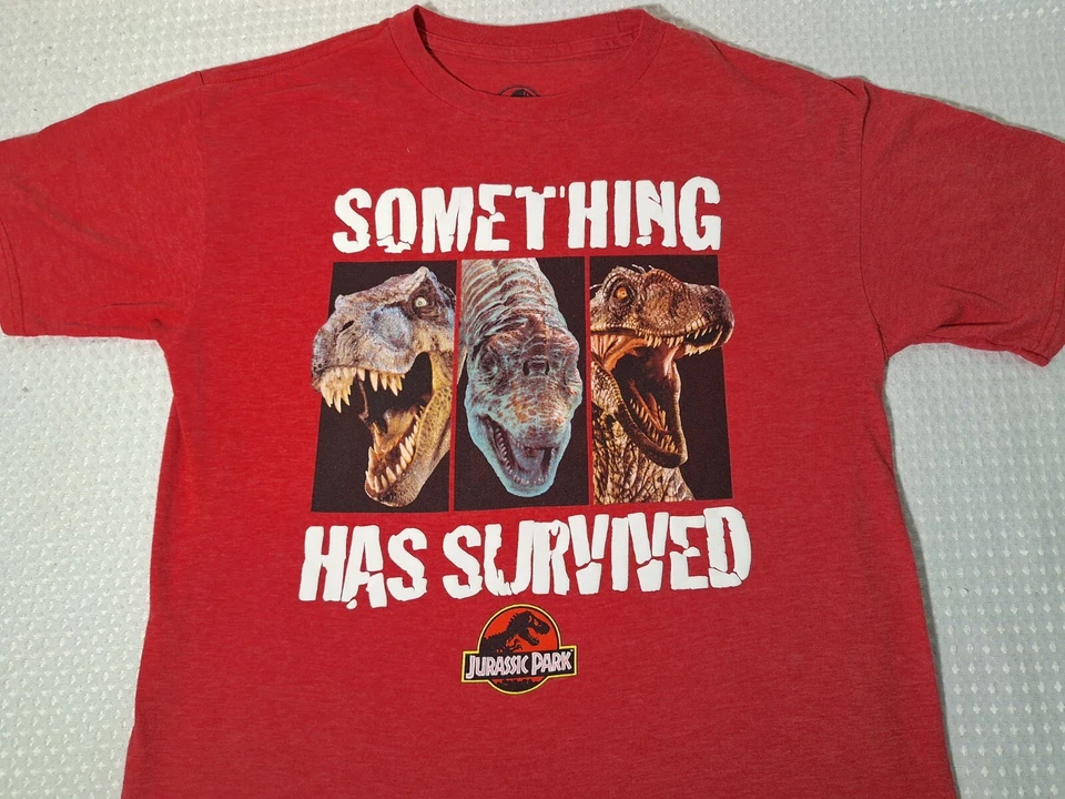 Camiseta Jurassic Park Something Has Survived roja mezcla de algodón niños talla 2XL 18 Foto 1 de 4
