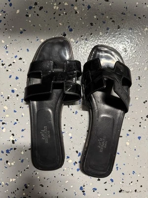 Sandalias Hermes Oran charol negro 37,5 - Necesita reparación Foto 1 de 4