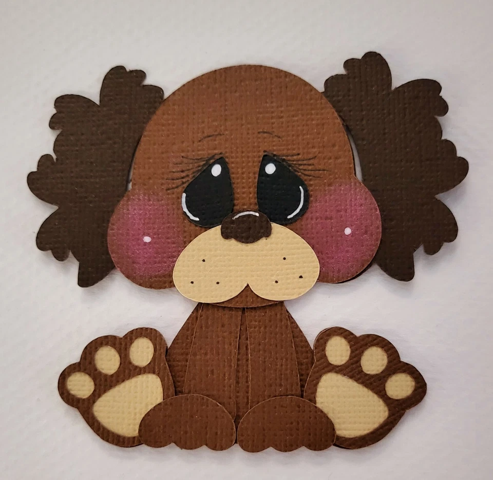 Pequeño cachorro marrón oscuro. Álbum de recortes, piezas de papel para hacer tarjetas Foto 1 de 1