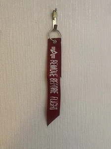 Llavero Alpha Industries Inc EE. UU. Rojo Etiqueta 'ELIMINAR ANTES DEL VUELO' - Imagen 1 de 2