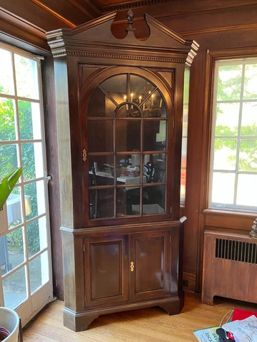 A Stickley Traditional style corner cupboard by. Solid mahogany with brass/glass Cover