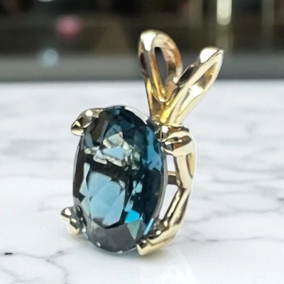 Piedras preciosas ovaladas naturales de topacio azul de Londres engarzadas en colgante de oro amarillo de 14 quilates con punta DBL Foto 1 de 4