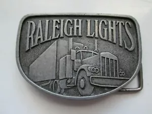 VINTAGE HALF-MOON BELT BUCKLE SAYS "RALEIGH LIGHT WITH TRUCK SCENE" EXCELLENT - Picture 1 of 2